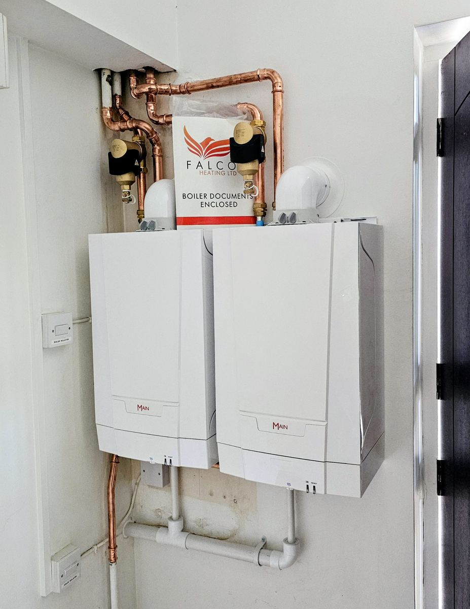 Twin boiler installation with Falcon Heating Ltd branded paperwork